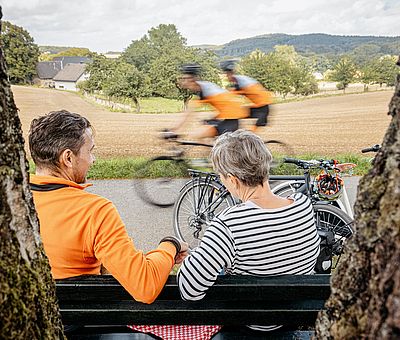 Zwei Personen machen eine Pause auf einer Bank